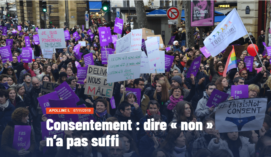 Foule lors d'une manifestation féministe. on voit des pancartes, violettes, blanches ou en carton, avec des slogans